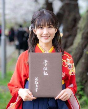 原田葵が法政大学の卒業式で桜の木の前で卒業証書を持って記念撮影